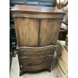 A serpentine fronted cabinet with pull out desk and 3 daw lower chest.