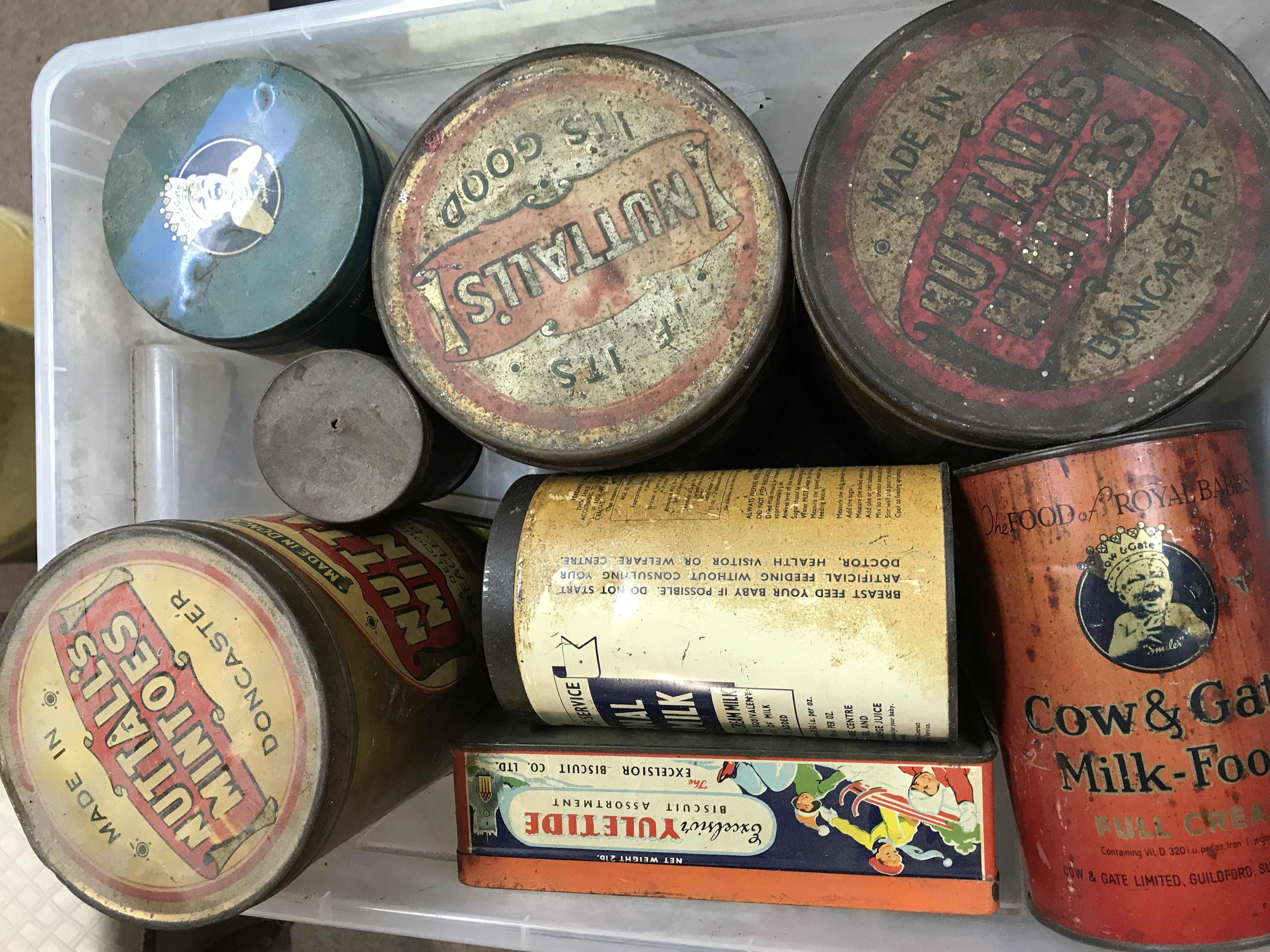 A box of old advertising tins .