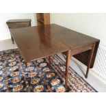 A George III mahogany drop leaf dining table with square tapering legs.