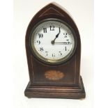 An Edwardian inlaid mahogany clock with an arch shaped vase a d white enamel dial
