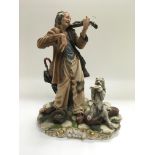 A Capodimonte figure of a homeless man playing a v