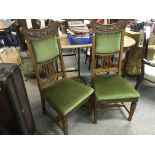 A set of six oak dining chairs with green fabric upholstered seats and backs.