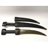 Pair of eastern black handled knives with curved blades in leather sheaths