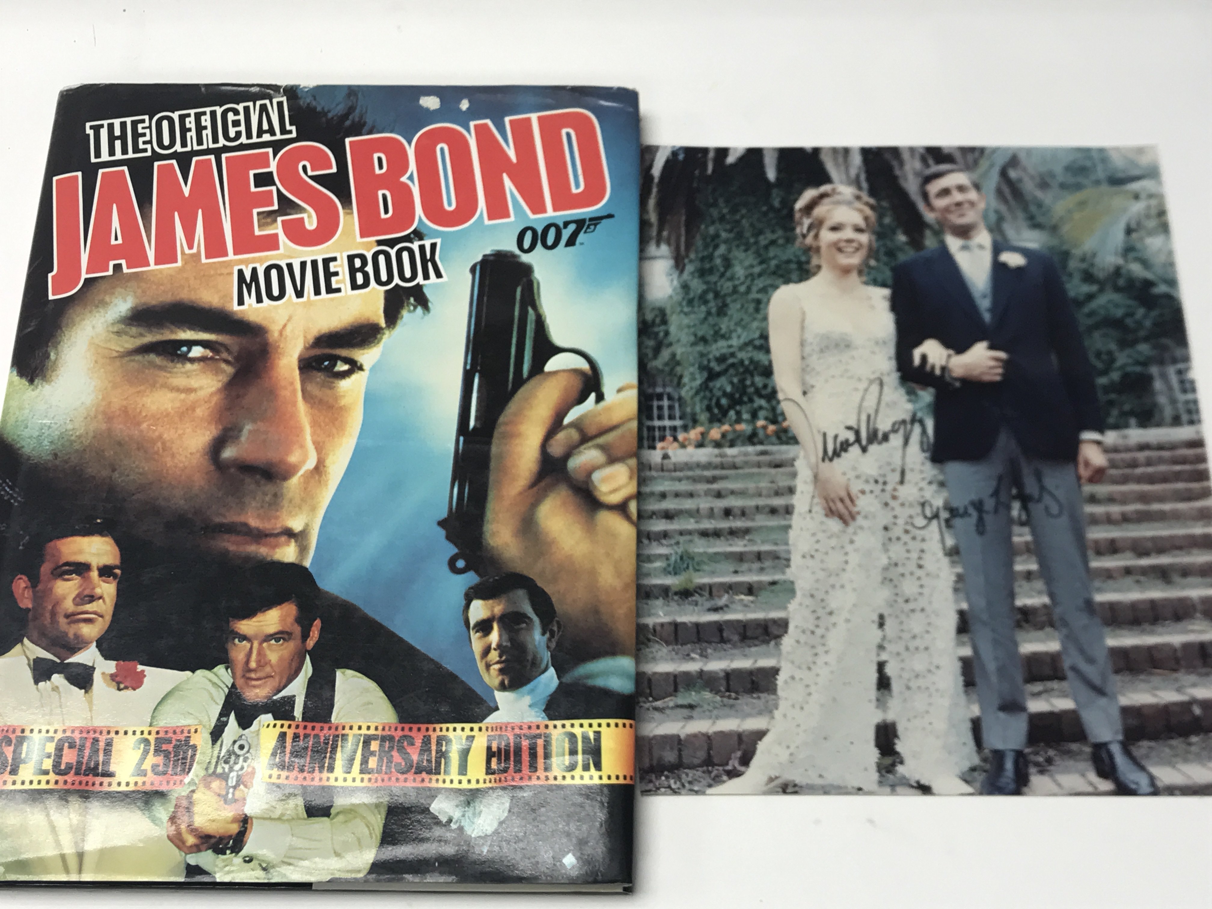 A signed photograph of Diana Rigg and George Lazenby together with The Official James Bind Movie Boo