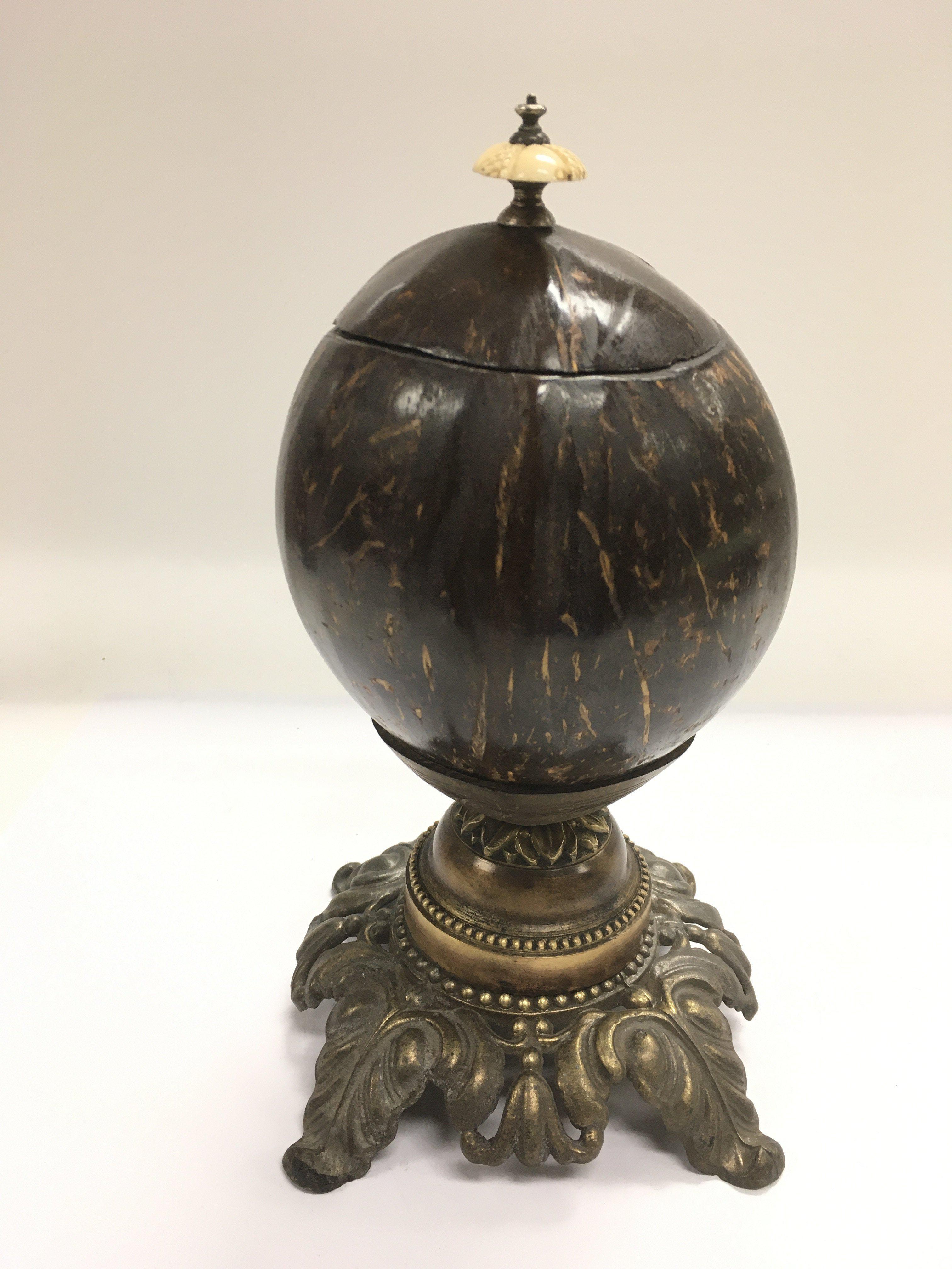 A Victorian polished coconut shell tea caddy raised on a metal base and with an ivory handle, approx