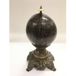 A Victorian polished coconut shell tea caddy raised on a metal base and with an ivory handle, approx