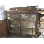 An oak display cabinet with a pair of glazed doors