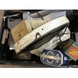 A box containing old advertising tins and scales