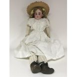 An early 20th century doll with leather and composition body and markings as pictured to the