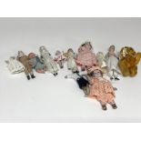 A collection of bisque miniature dolls and a miniature bear.