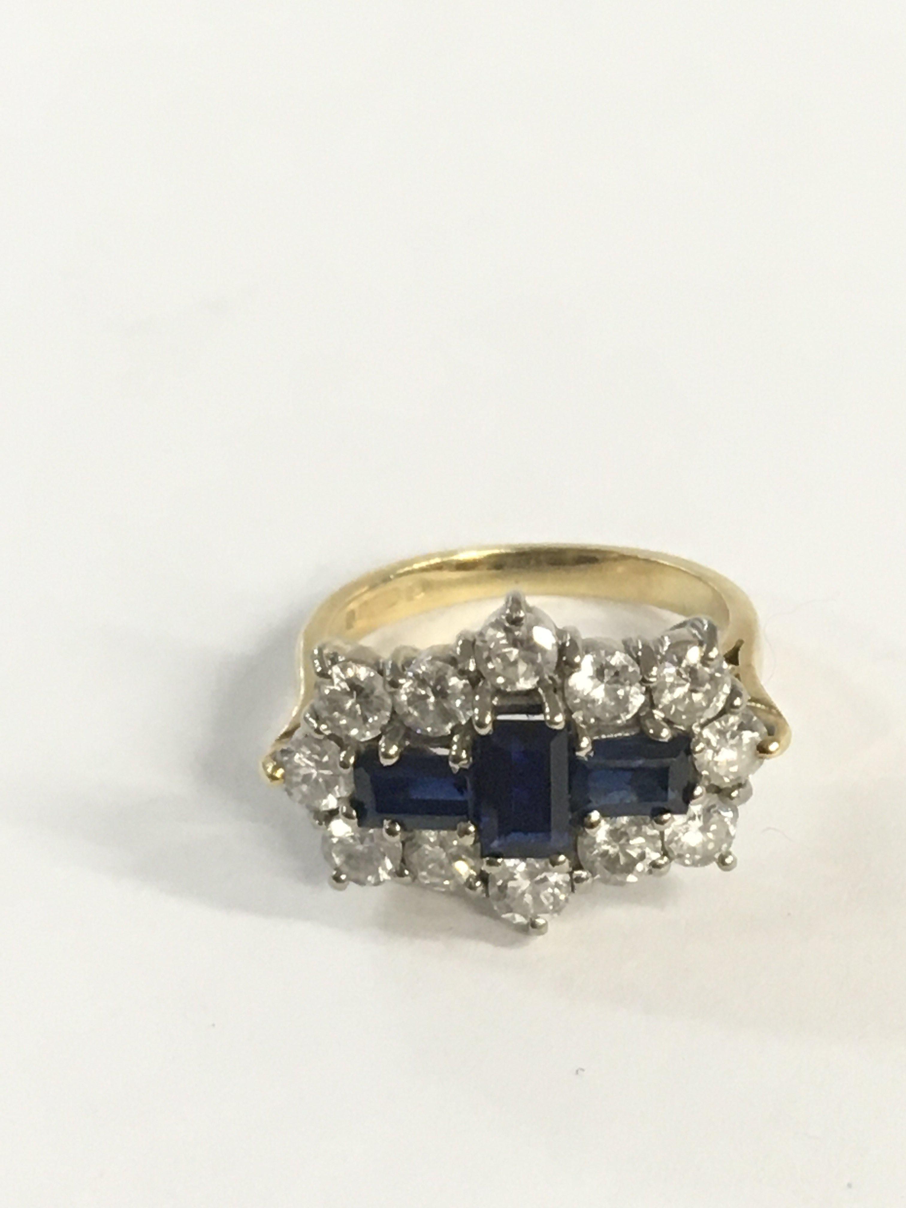 An 18c gold ring set with three sapphires and diam