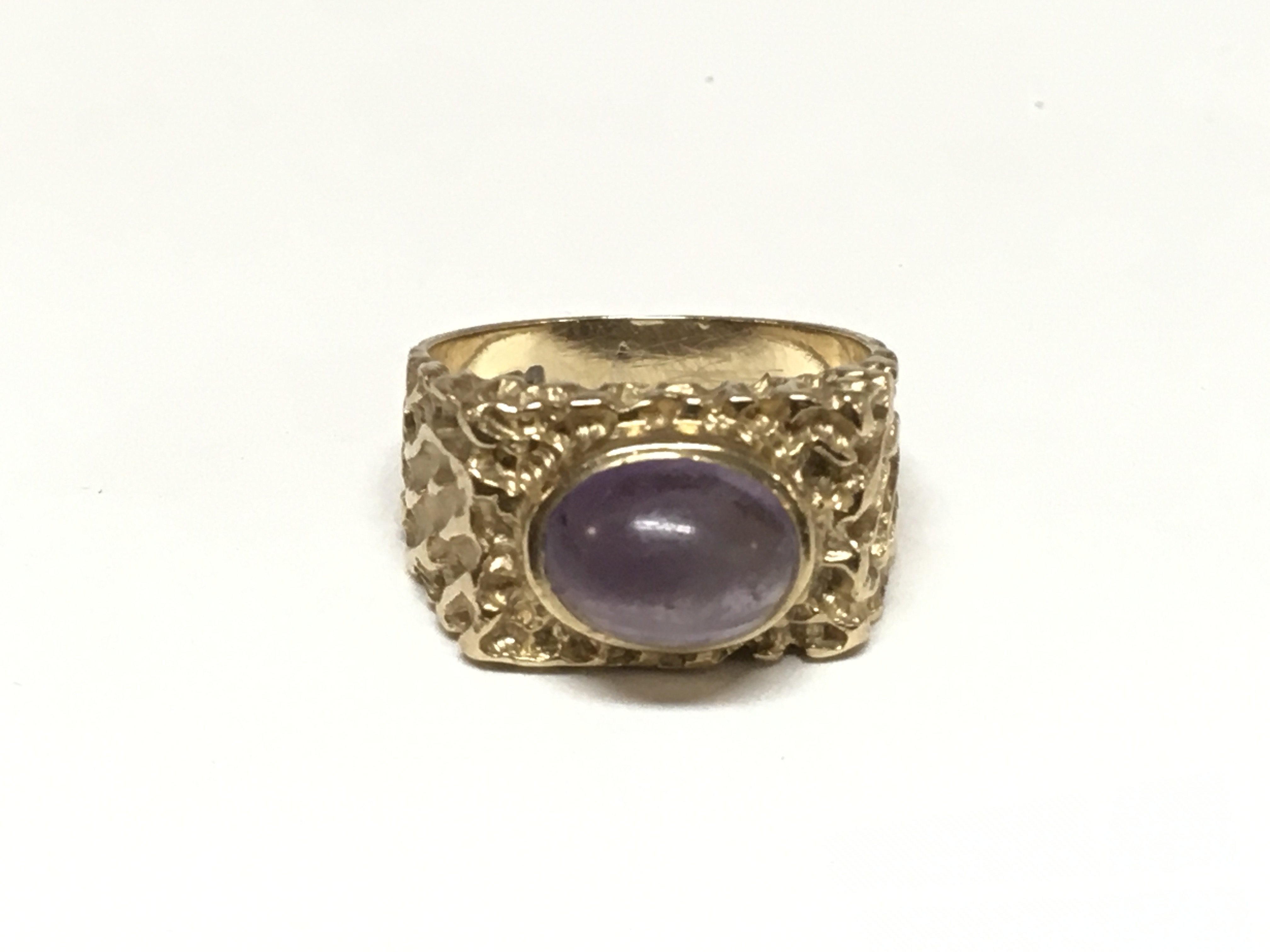 A 9ct gold ring set with an amethyst cabochon. The