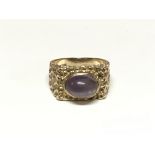 A 9ct gold ring set with an amethyst cabochon. The