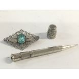 A silver pen, silver thimble and a silver brooch.