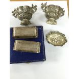 Some silver napkin rings and two ornately decorate