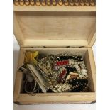 A patterned wooden box containing costume jeweller