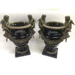 A pair of ceramic urns with decorative metal fitti