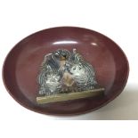 An unusual cold painted metal dish with raised cas