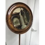 An early 19th century toilet mirror the circular mirror above a turned column on carved base .