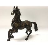A heavy bronze figure of a stallion together with