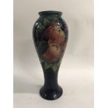 A moorcroft vase decated with fruit birds flowers