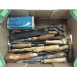A box of vintage tools including chisels, a boxed
