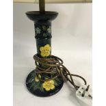 A moorcroft side lamp decorated with flowers and f