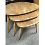 A nest of three Ercol pebble tables .