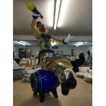 A Large Murano glass clown seated on a glass barre
