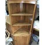 A Ercol corner cabinet fitted with open selfs and