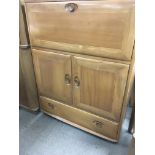 A Ercol cabinet the fall front with fitted interio