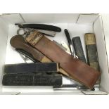 A collection of vintage razors and a leather strop