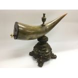 An old bull's horn snuff mull mounted on a metal b