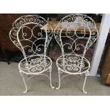 A pair of coated wrought iron vintage garden seats