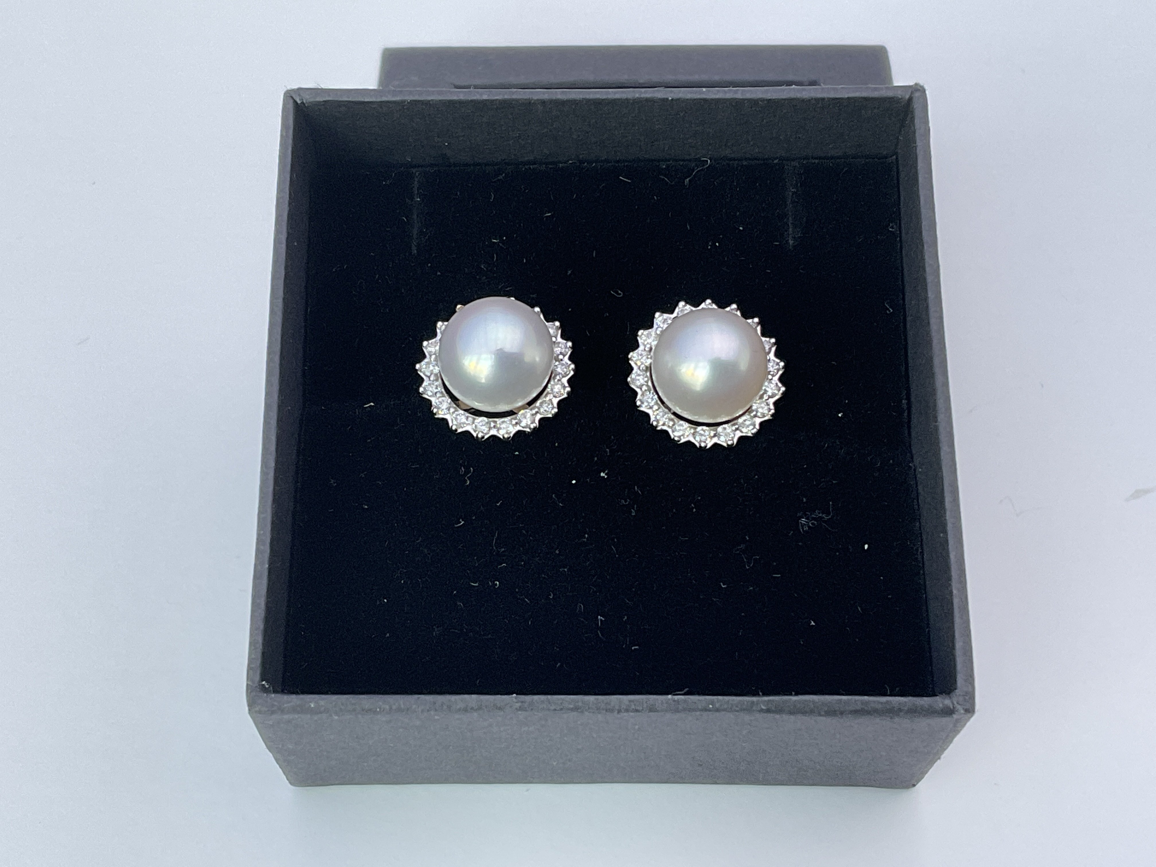 A pair of 9ct white gold halo studs set with cultu