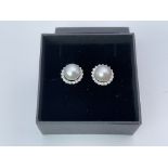 A pair of 9ct white gold halo studs set with cultu