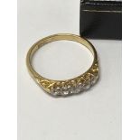 An 18 ct gold ring inset with a row of five Diamon