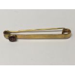 A 9 ct gold tie pin inset with garnet..