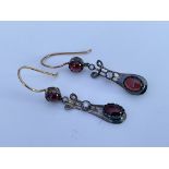 A pair of diamond and cabochon garnet drop earring