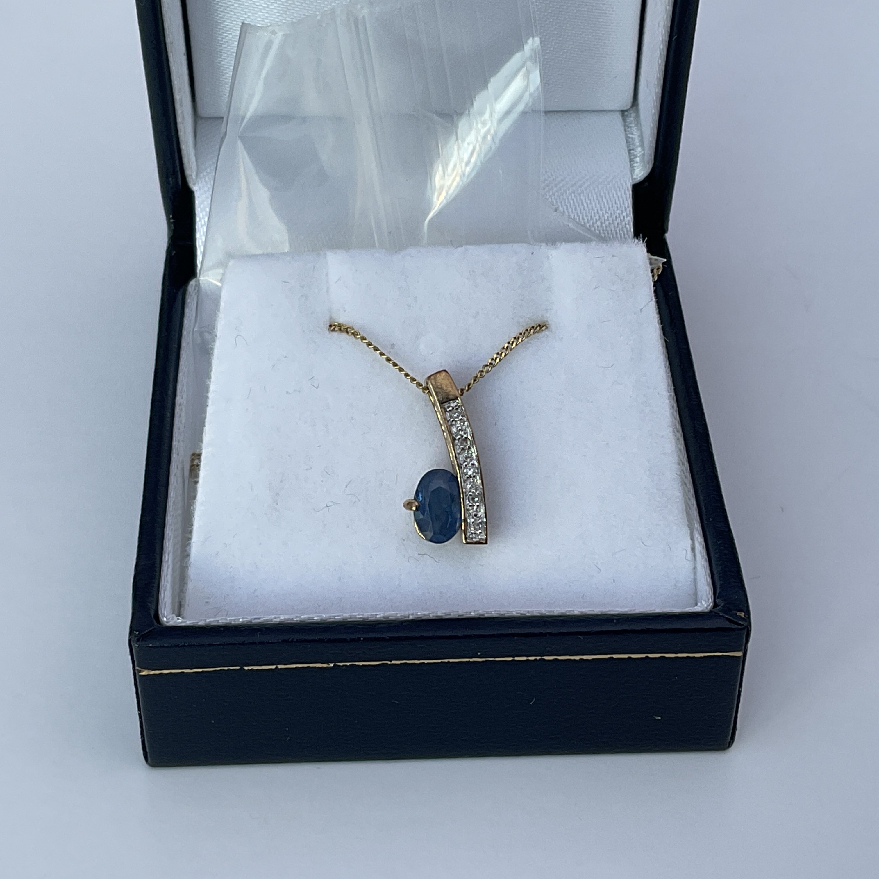 A 9ct yellow gold sapphire and diamond pendant wit