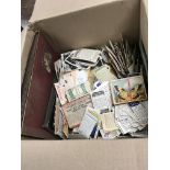 A large box of cigarette cards that are both loose