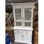 A White painted modern cabinet with glazed doors a
