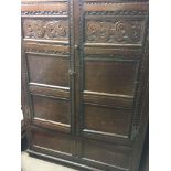 An 18th century oak wardrobe with a pair of carved