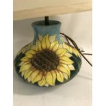 A Moorcroft table lamp decorated with sunflowers.