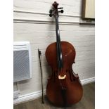 A cello, with bow and a canvas case. The model is