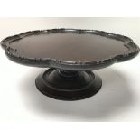 A mahogany revolving tray with scalloped edges on