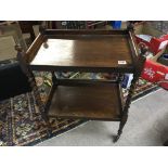 An oak two tier tea trolley with barley twist supp