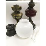 Two oil lamps, one with a ruby glass reservoir.