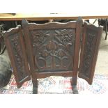 An Art Nouveau carved Mahogany folding fire screen.