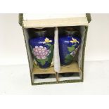 A pair of 20th century cloisonnÃ© vases decorated with flowers on stands. In a fitted box